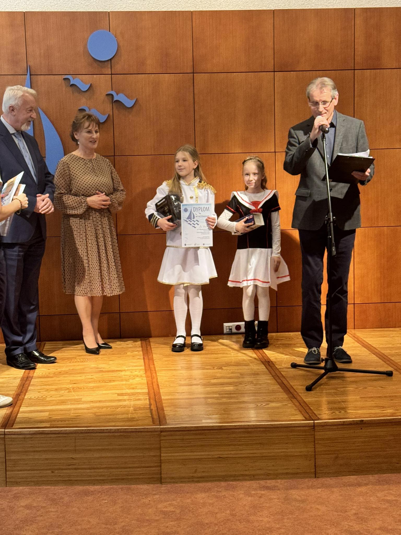 3 osoby dorosłe i dwie uczennice. Wśród dorosłych prezydent Wejherowa Krzysztof Hildebrandt. Dziewczynki trzymają w rękach nagrody.